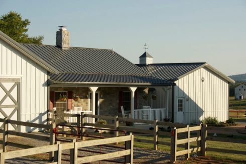 Nestled between the metal horse barn (left) and garage (right), a ...